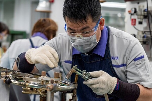 En håndverker som lodder metallbiter med blyfri loddetinn.