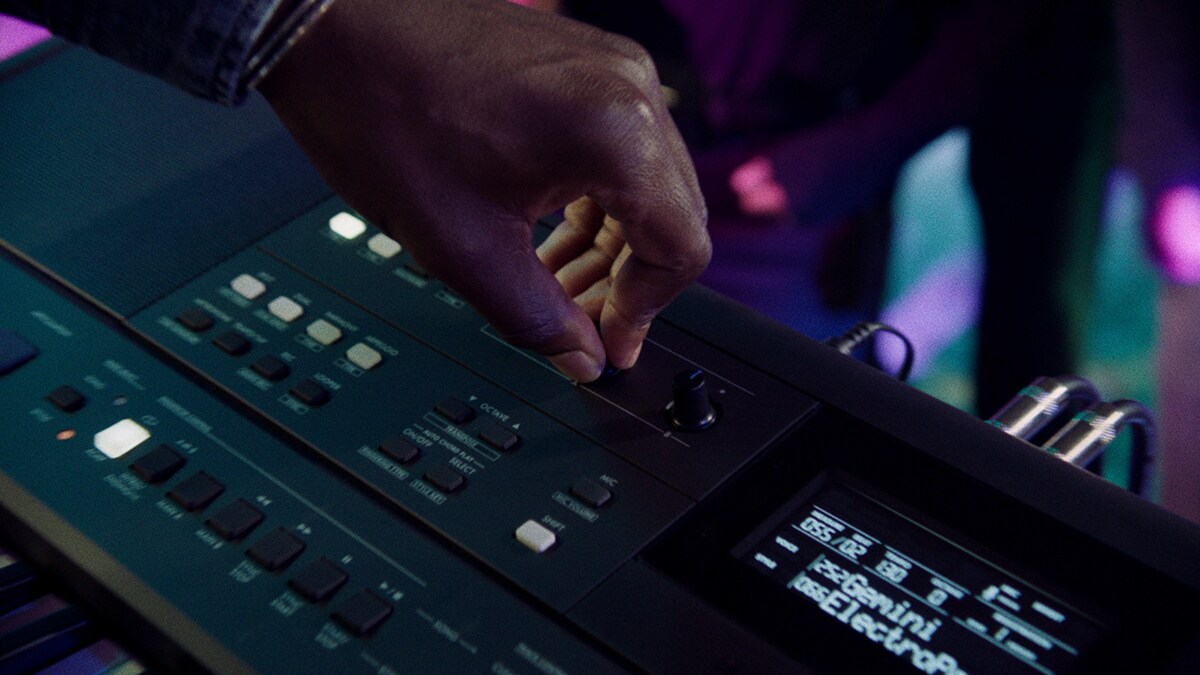 En person som justerer en Live Control-knapp på PSR-E483