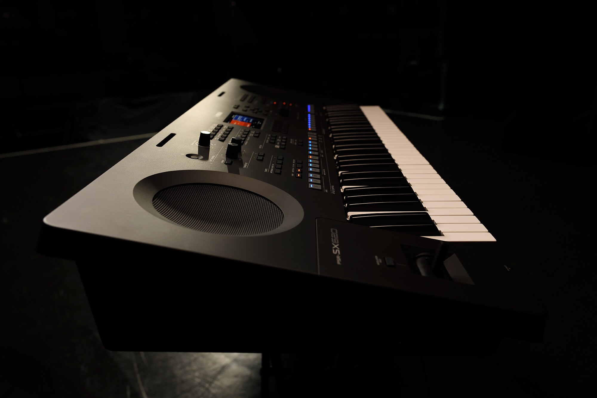 Et keyboard på et stativ under scenelys