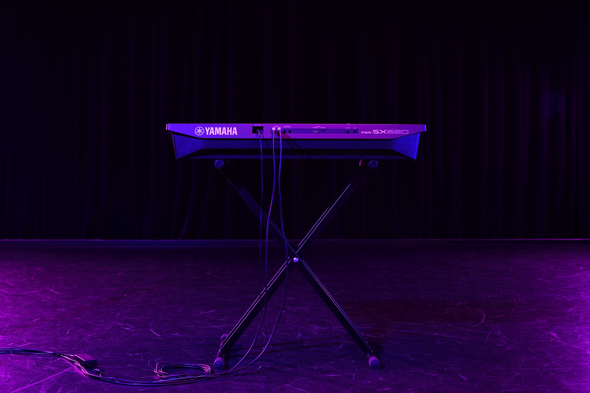 Et keyboard på et stativ under scenelys