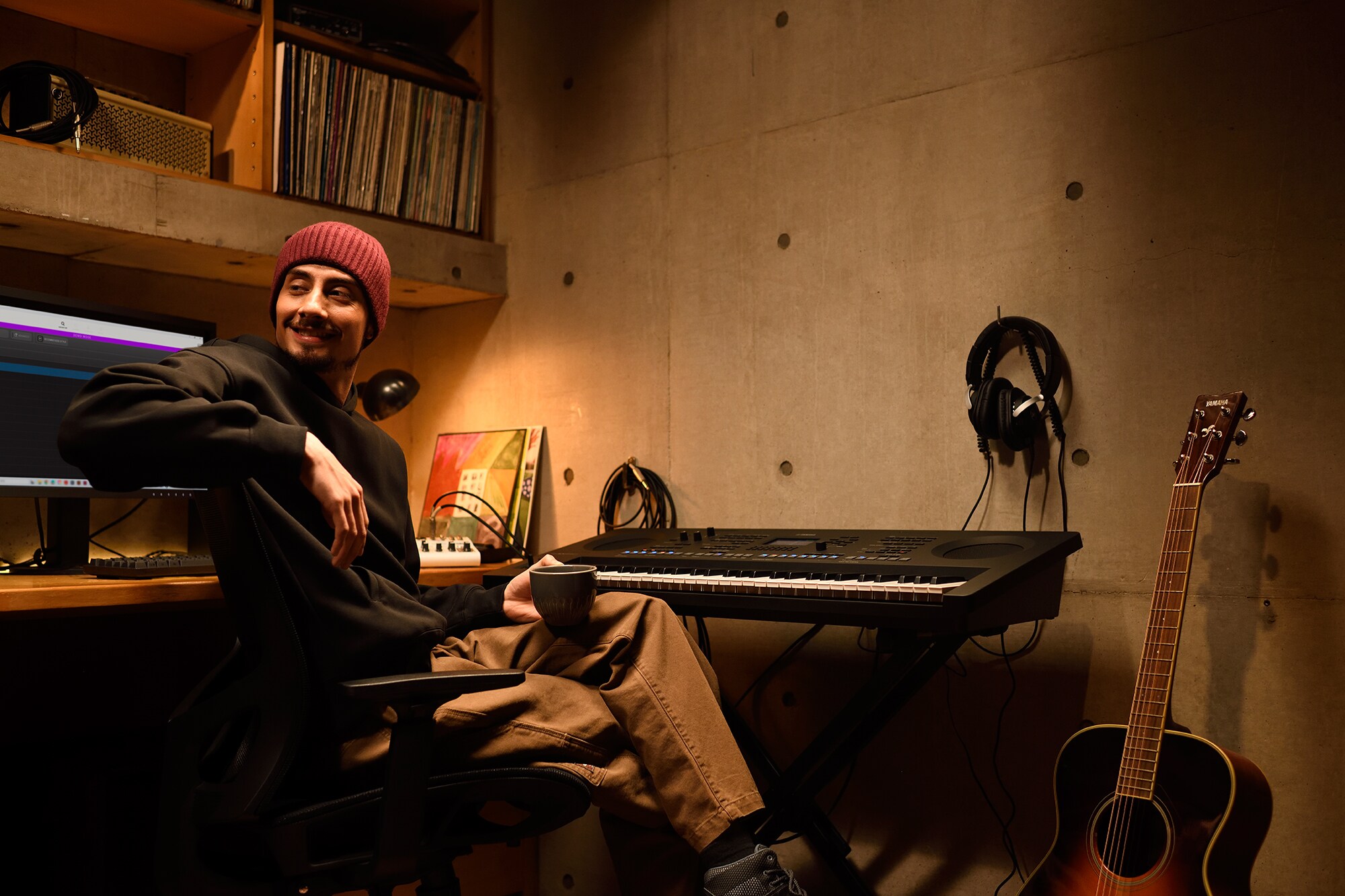 En musikkarbeidsplass hjemme med datamaskin og keyboard, som viser en keyboardist som jobber i hjemmestudioet sitt