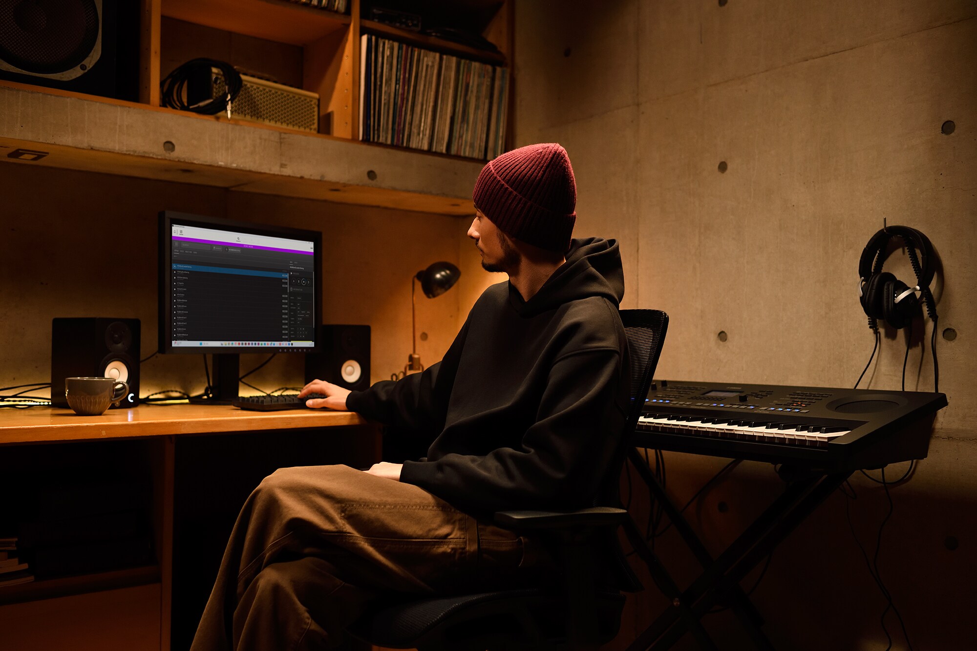 En musikkarbeidsplass hjemme med datamaskin og keyboard, som viser en keyboardist som jobber i hjemmestudioet sitt
