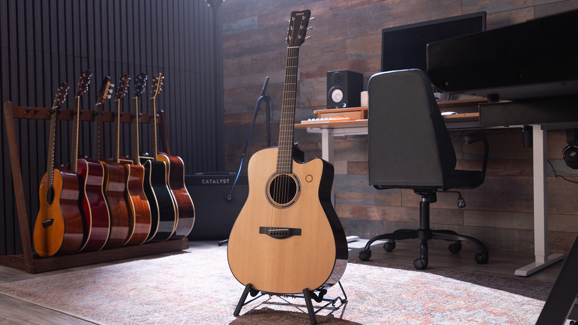 En TAG3 C akustisk gitar plassert i midten av et hjemmestudio