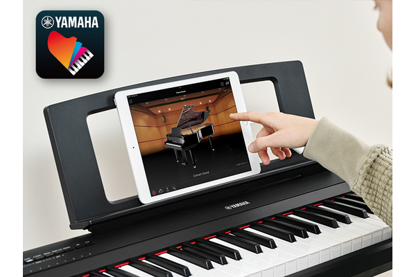 The Yamaha “Smart Pianist” app icon, together with a tablet placed on the music stand of the Piaggero
