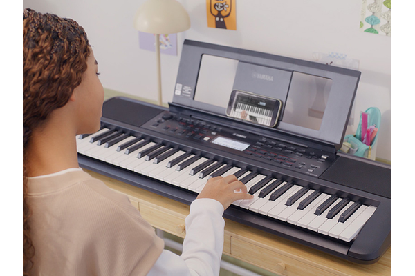 Girl is playing the YPT-380 with satisfaction.