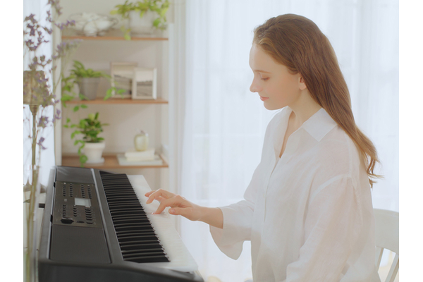Woman playing the YPT-W320 with one hand.
