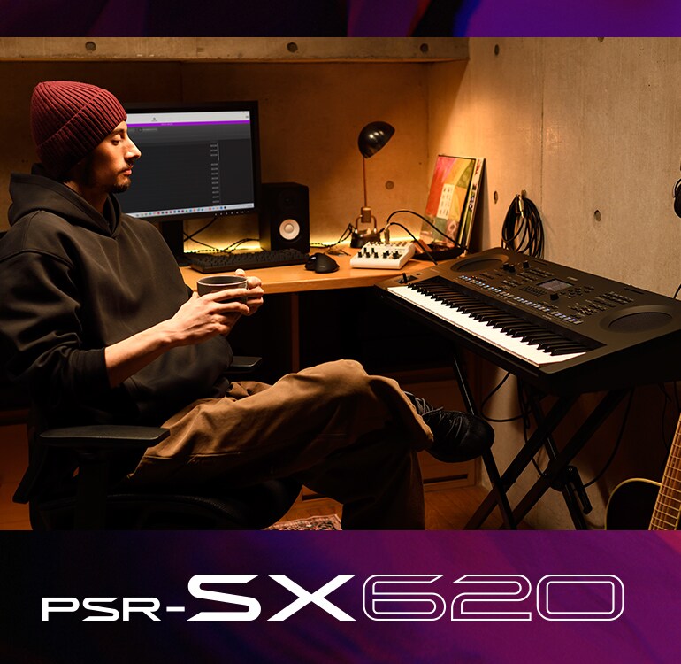 Person som sitter ved et PSR-SX-keyboard i et hjemmestudio og drikker kaffe.