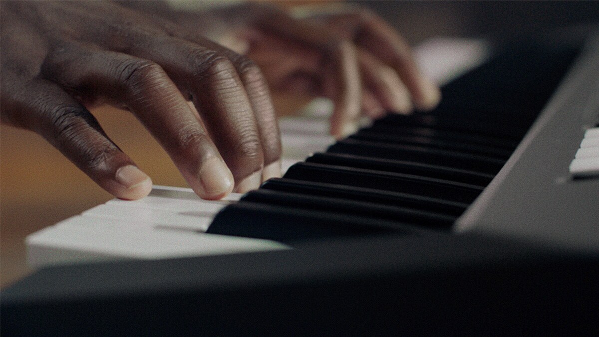 En person som spiller på Yamaha PSR-E483