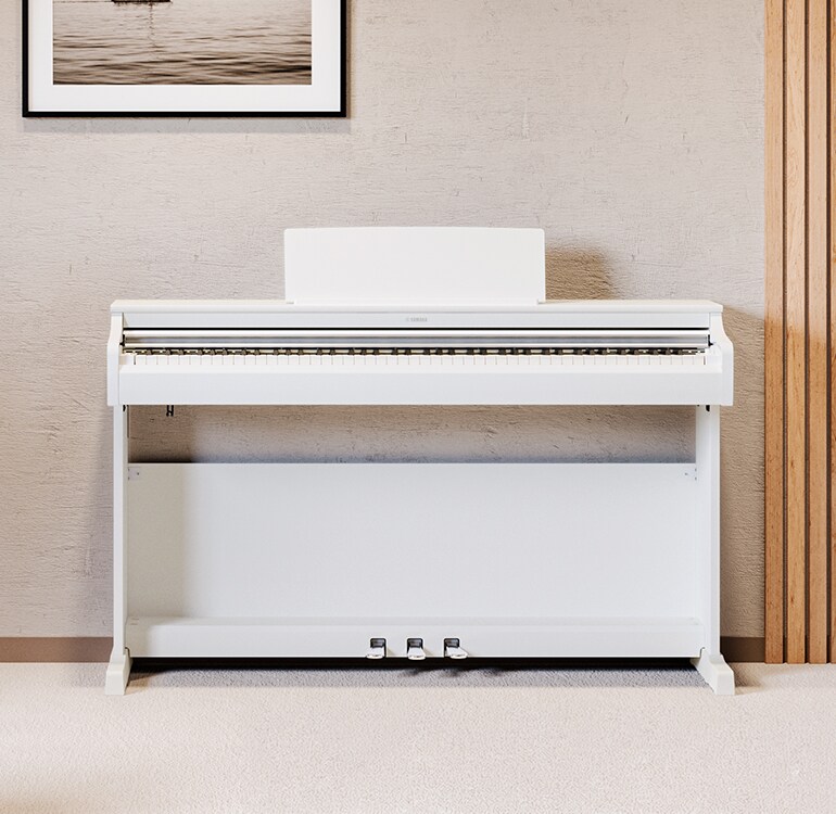 En stue med et hvitt ARIUS-piano, stueplanter og en sofa, harmonisk integrert i interiøret