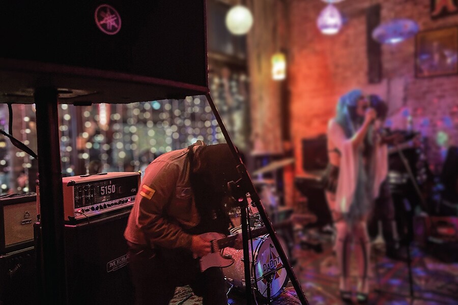 Band performing on stage at Daddy Diamonds with Yamaha DZR loudspeakers visible in the foreground.